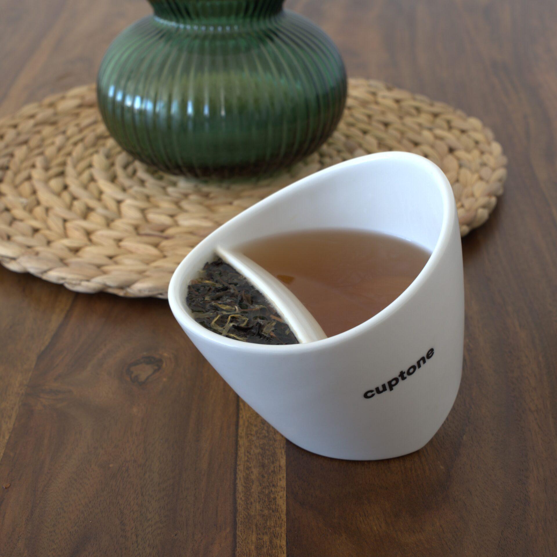 cuptone teacup steeping tea placed on wooden table