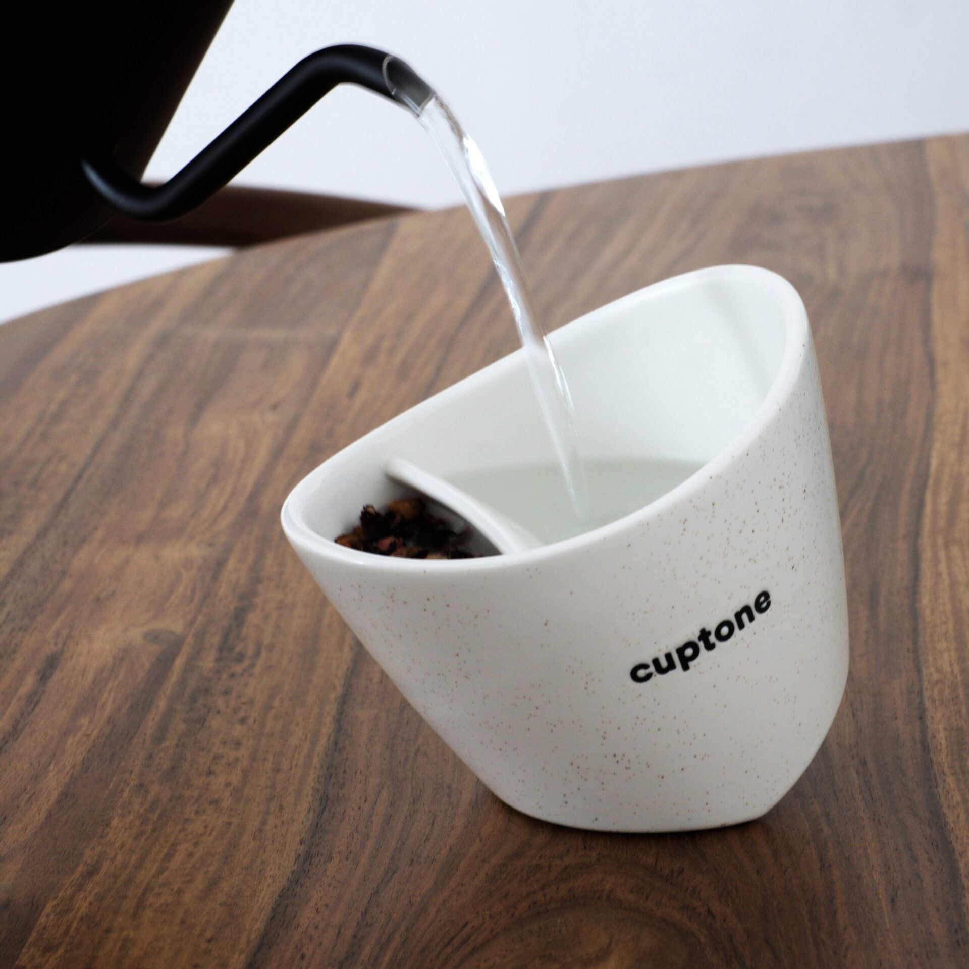 Pouring hot water into cuptone teacup using gooseneck kettle